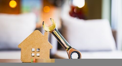 Wooden,house,model,with,metal,wrench,symbolizing,home,maintenance,,repair